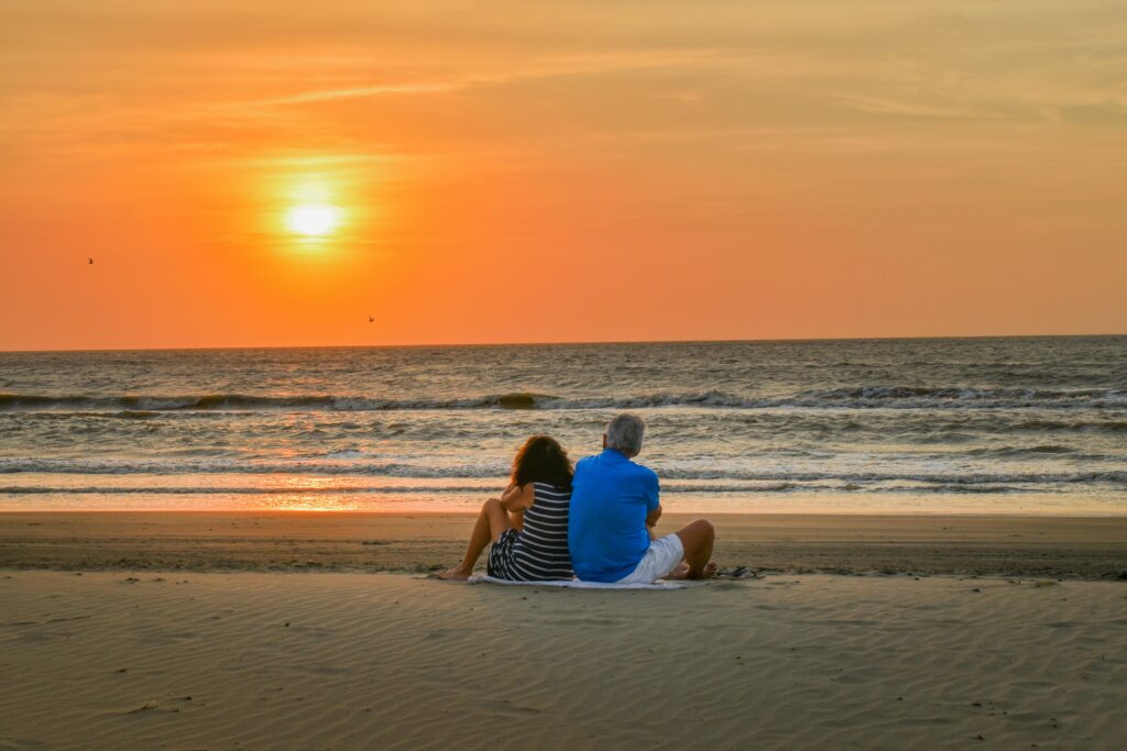 A couple enjoys a romantic sunset on a serene beach in Cartagena, Colombia.