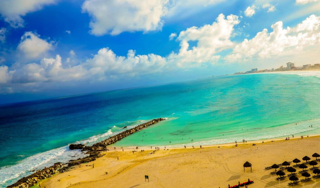 A breathtaking aerial view of a vibrant beach in Cancun, featuring golden sands and turquoise waters.